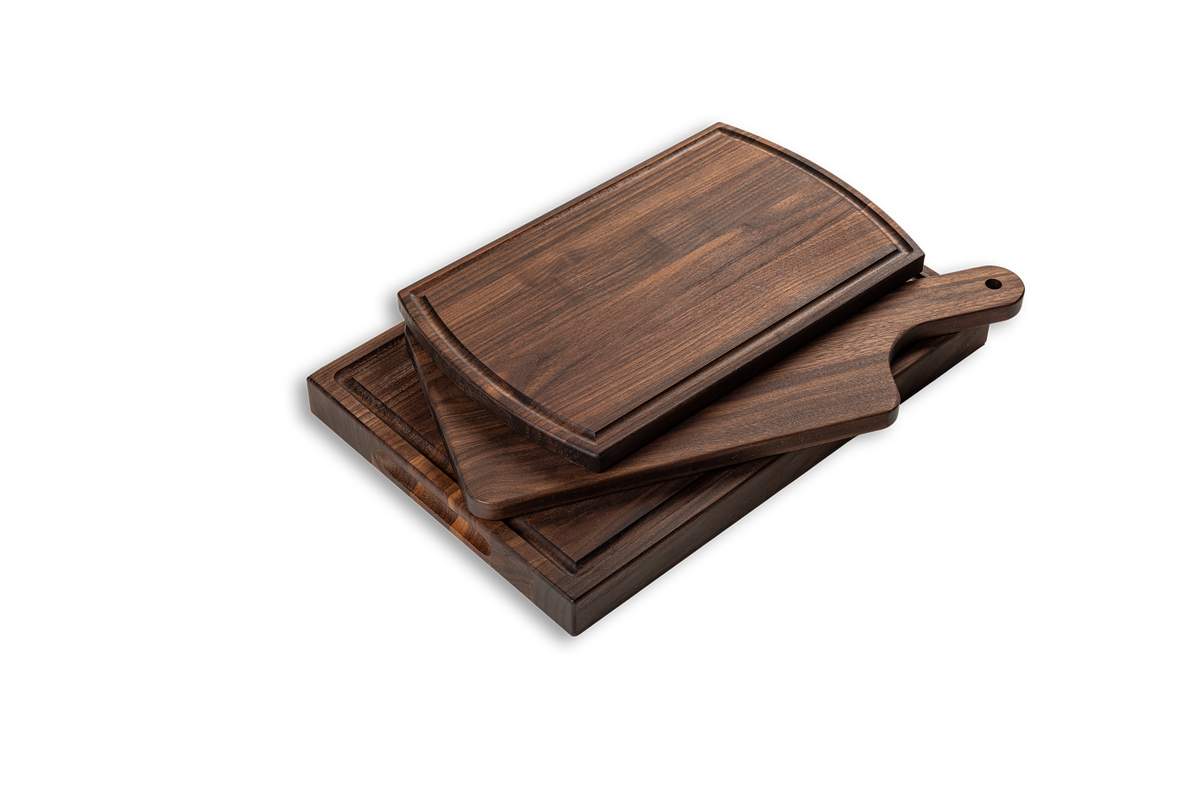 A set of three chop chop walnut wood cutting boards, varying in size, with a handle on the large serving board. They are displayed stacked, showcasing their different sizes and solid walnut wood grain.